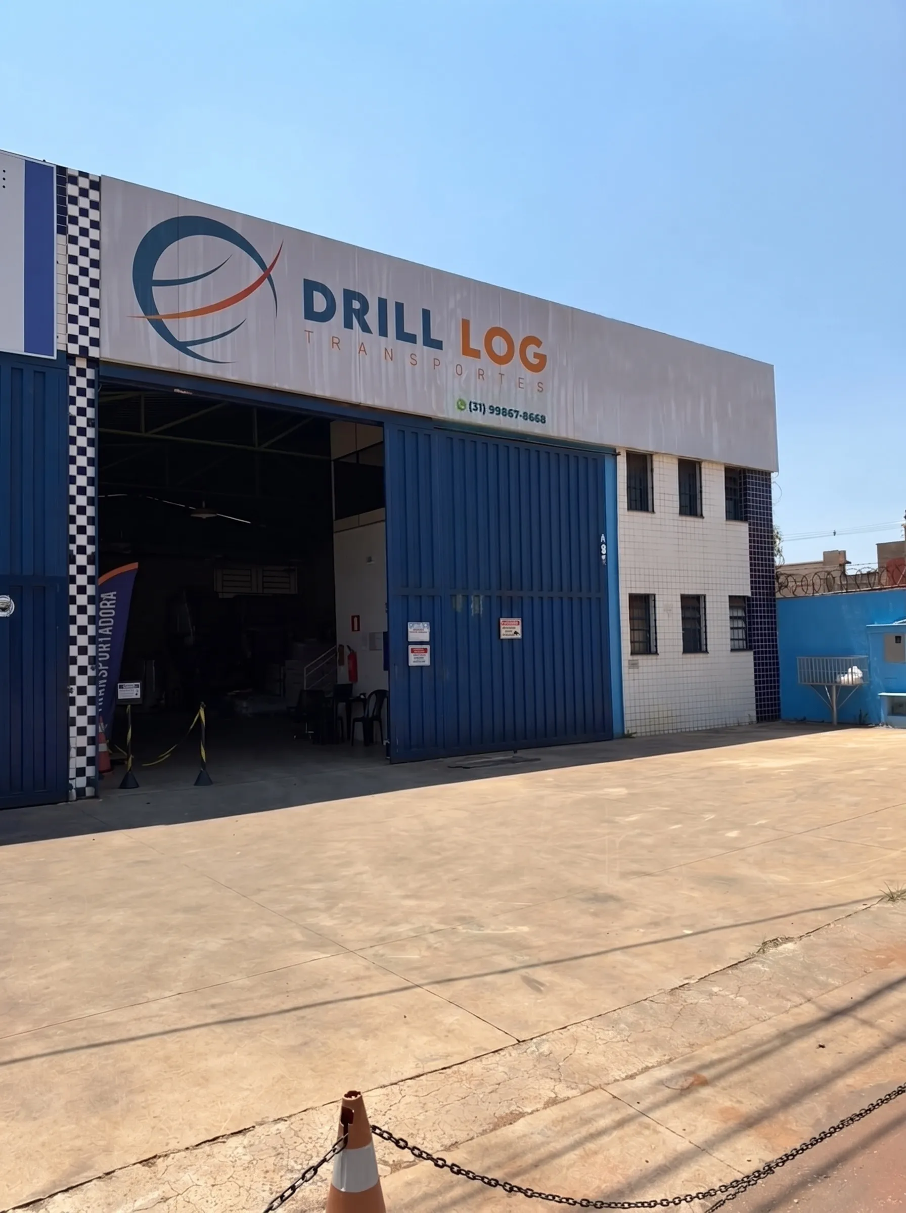Fachada do galpão da Drill Log Transportes, com o portão aberto